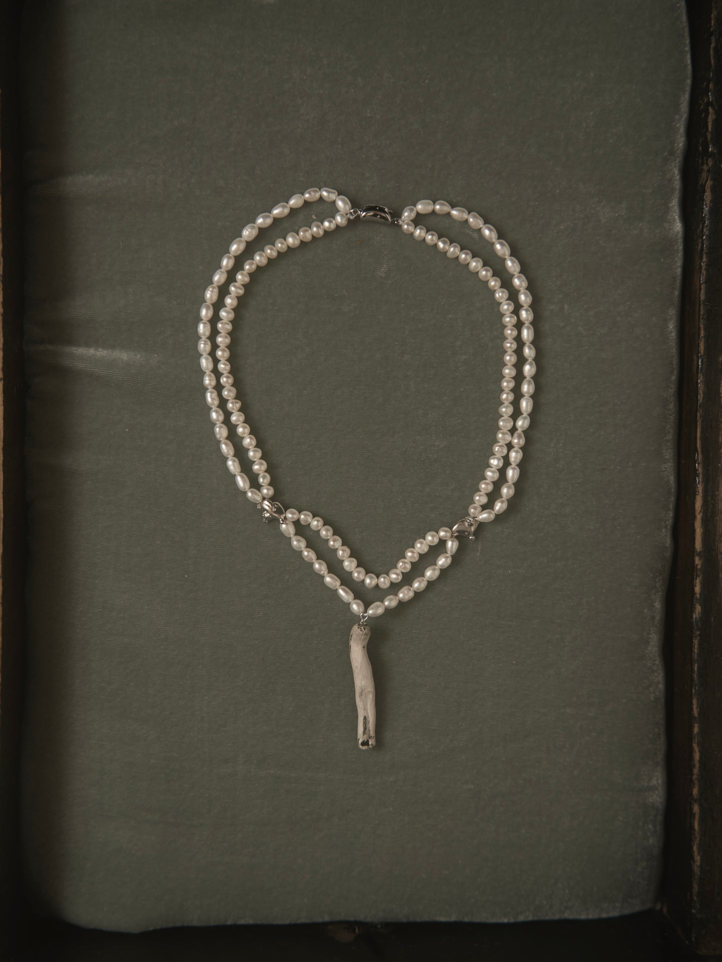 DOUBLE-LAYERED PEARL NECKLACE WITH CERAMIC DOLL PENDANT